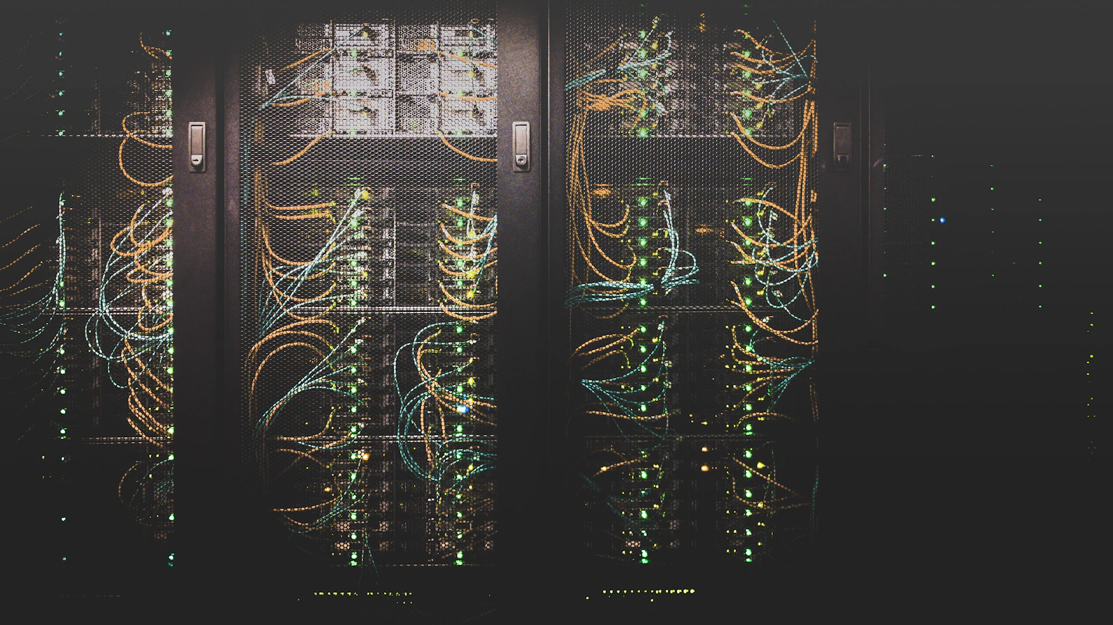 Corredor de um data center com fileiras de servidores e iluminação baixa